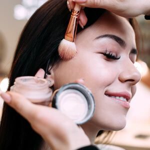 Girl is smiling doing makeup